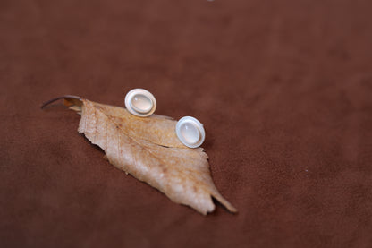 The Classic B & W Onyx Ear Stud — white oval studs on dried leaf