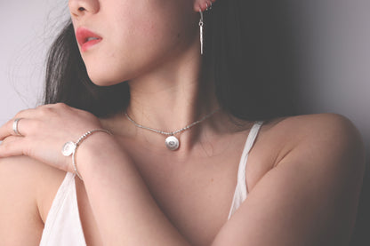 The Lotus Set — model wearing matching lotus-pendant necklace and bracelet