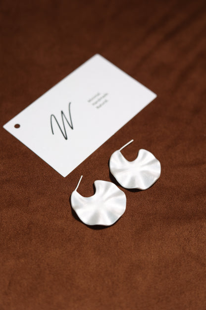 The Windmill-Earrings — windmill-shaped earrings beside branded card