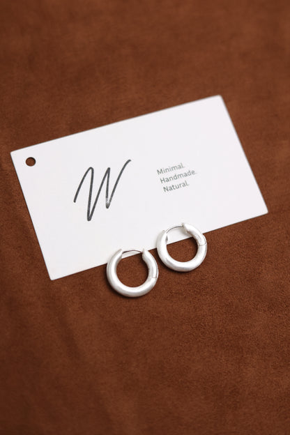 The Minimalist Basic Hoop — pair of hoops beside a brand card