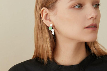 The Stones-Earrings — silver-tone drop earring with green accent worn on an ear
