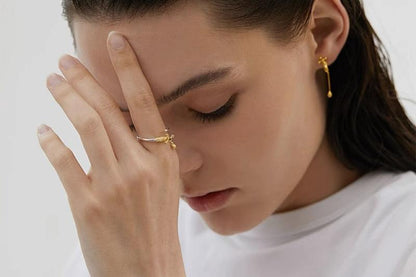 Gold-tone tap-shaped ring worn on a hand