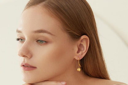 The Tulips-Earrings — gold-tone tulip earring worn on an ear