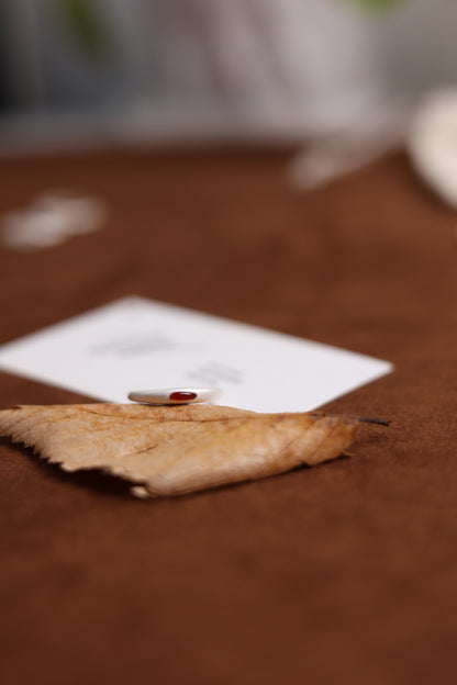 The Red Agate Silver Ring — low-angle view of red-stone ring on leaf