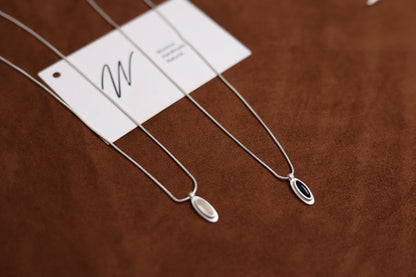 The B & W Onyx Necklace — black and white oval pendant necklaces side by side