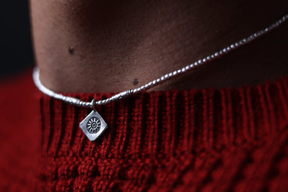The SUN Set — sun-pendant necklace worn with red knitwear