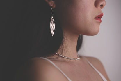 Handcrafted Minimalist Silver Irregular Beaded Necklace — side view of necklace worn with leaf earring
