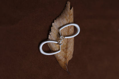 The Minimal U Ear Hoops — U-shaped hoops arranged on leaf