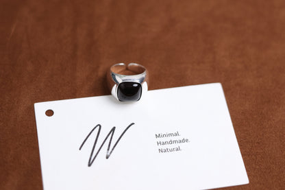 The Smoky Quartz Signet Ring — dark-stone signet ring beside branded card