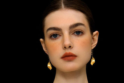 The Leaves -Earrings — model wearing gold-tone leaf earrings