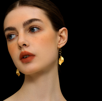 The Leaves -Earrings — side view of model wearing gold-tone leaf earrings