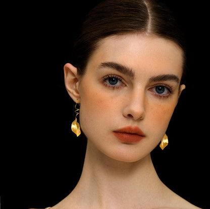 The Leaves -Earrings — front view of model wearing gold-tone leaf earrings