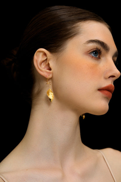 The Leaves -Earrings — gold-tone leaf earring worn on an ear