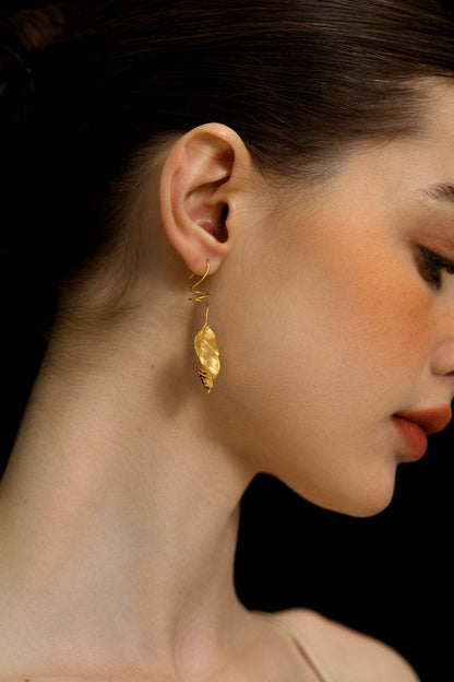 The Leaves -Earrings — close-up of gold-tone leaf earring worn on an ear