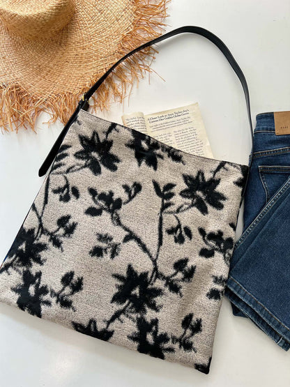 The Silk Bag — black-and-white floral bag beside book and denim
