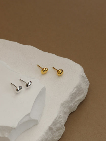 The Dune — small stud components in both finishes beside white stones