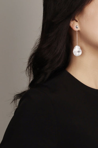 The Dune — model wearing silver-tone oval drop earring with black top