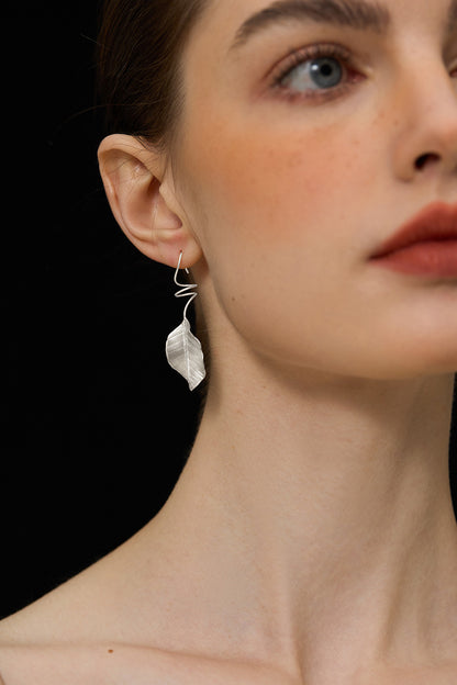 The Leaves -Earrings — silver-tone leaf earring worn on an ear