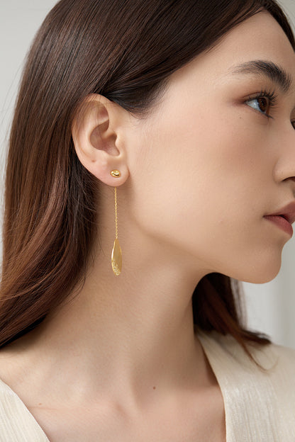 The Dune — model wearing long gold-tone oval earring